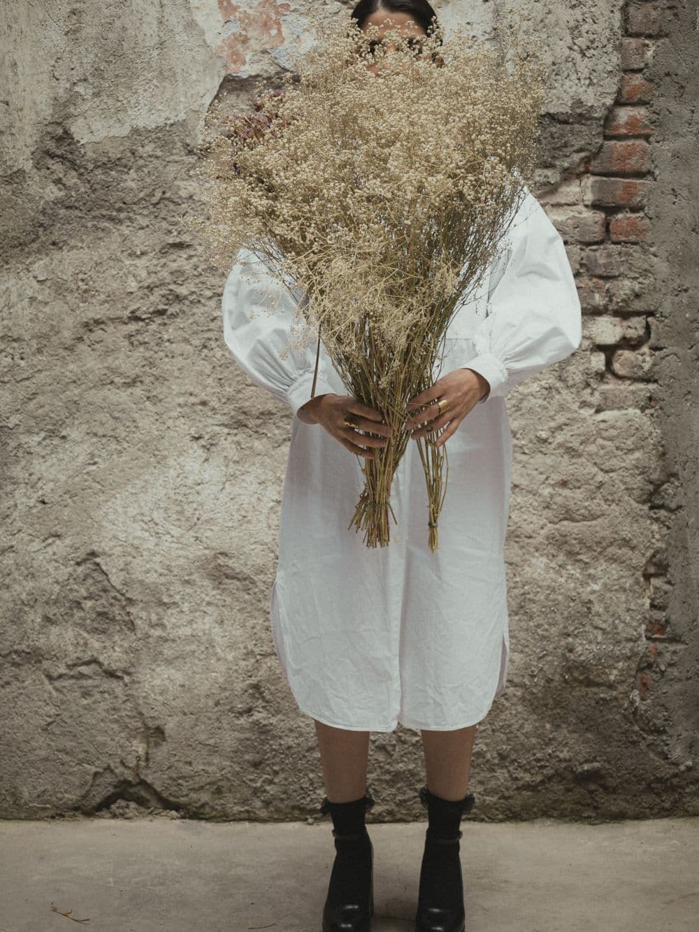 Model holding a bouquet of dried flowers